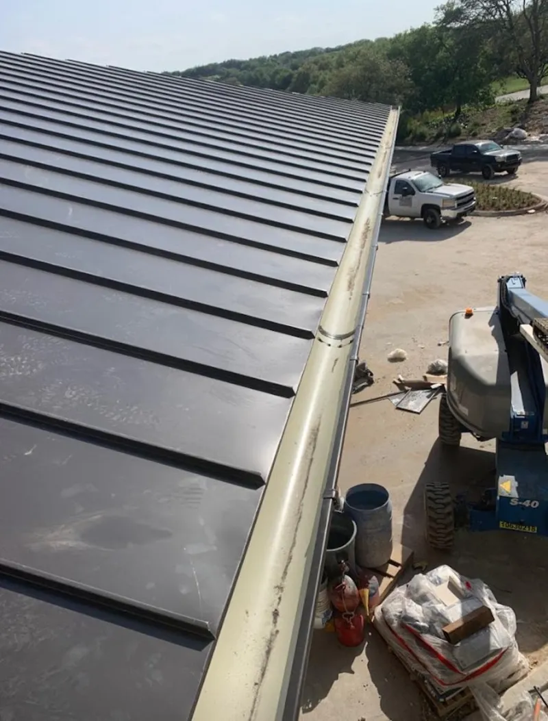 Standing seam panel and gutter detail on a metal roofing jobsite in Valrico